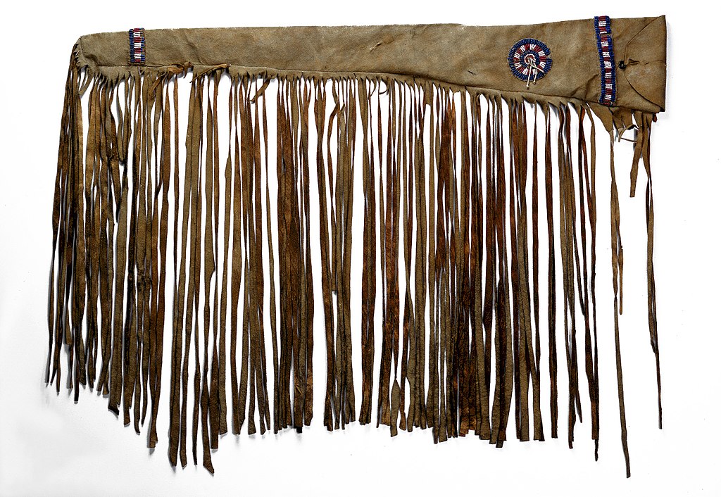 Image shows a plains first nations rifle guncase made from the hide of a buffalo. It has beadwork and fringes.